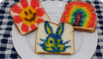 bread with smiling flower, bunny and rainbow sprinkle artwork